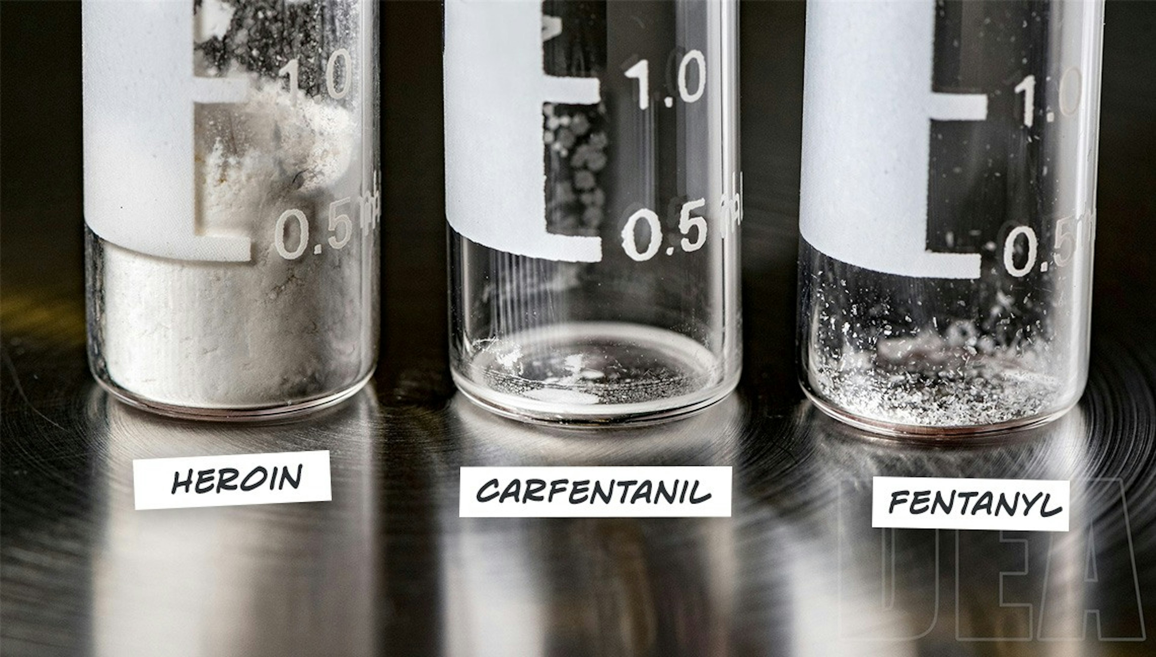 Three test tubes showing the same lethal dosage of fentanyl is barely visible compared to lethal doses of heroin and carfentanil.